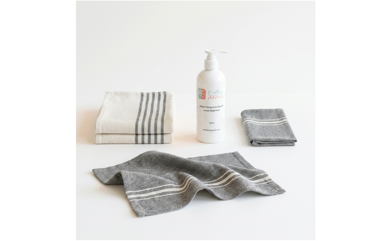 Barrydale Medium Country Towels with striped ends, napkins, and Mellow & Peachy Lemon Verbena & Tea Tree Hand Wash arranged as a coordinated gift set.