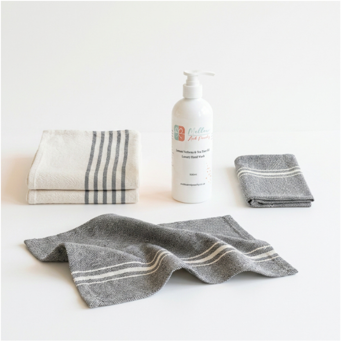 Barrydale Medium Country Towels with striped ends, napkins, and Mellow & Peachy Lemon Verbena & Tea Tree Hand Wash arranged as a coordinated gift set.