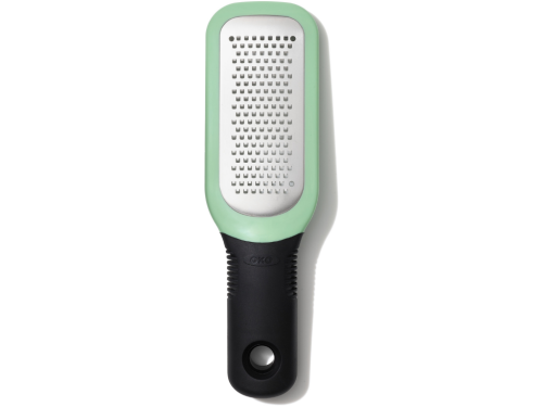 OXO Good Grips Etched Ginger & Garlic Grater with stainless steel etched teeth, soft grip handle, and snap‑on scraper cover shown in a modern kitchen setting.